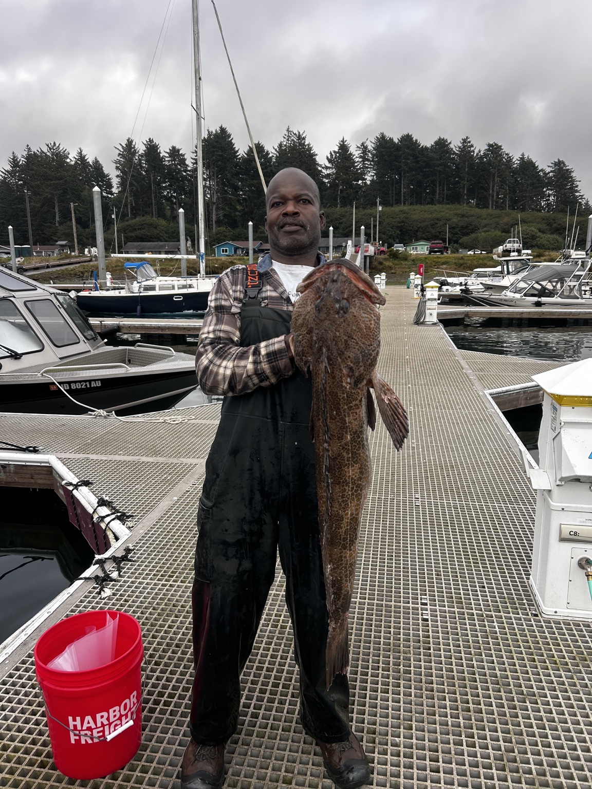 Capt. Lamont holding a lingcod on the dock at La Push